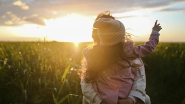 Frau mit Tochter am Arm vor Maisfeld, Sonnenuntergang, Energiewende, EG Austria, Energiegemeinschaft